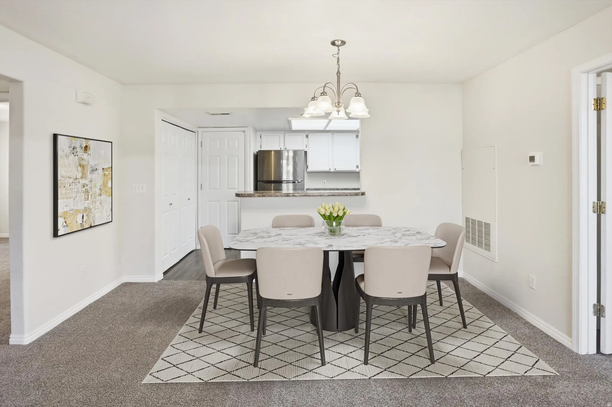 Dining space featuring dark carpet and hanging lights