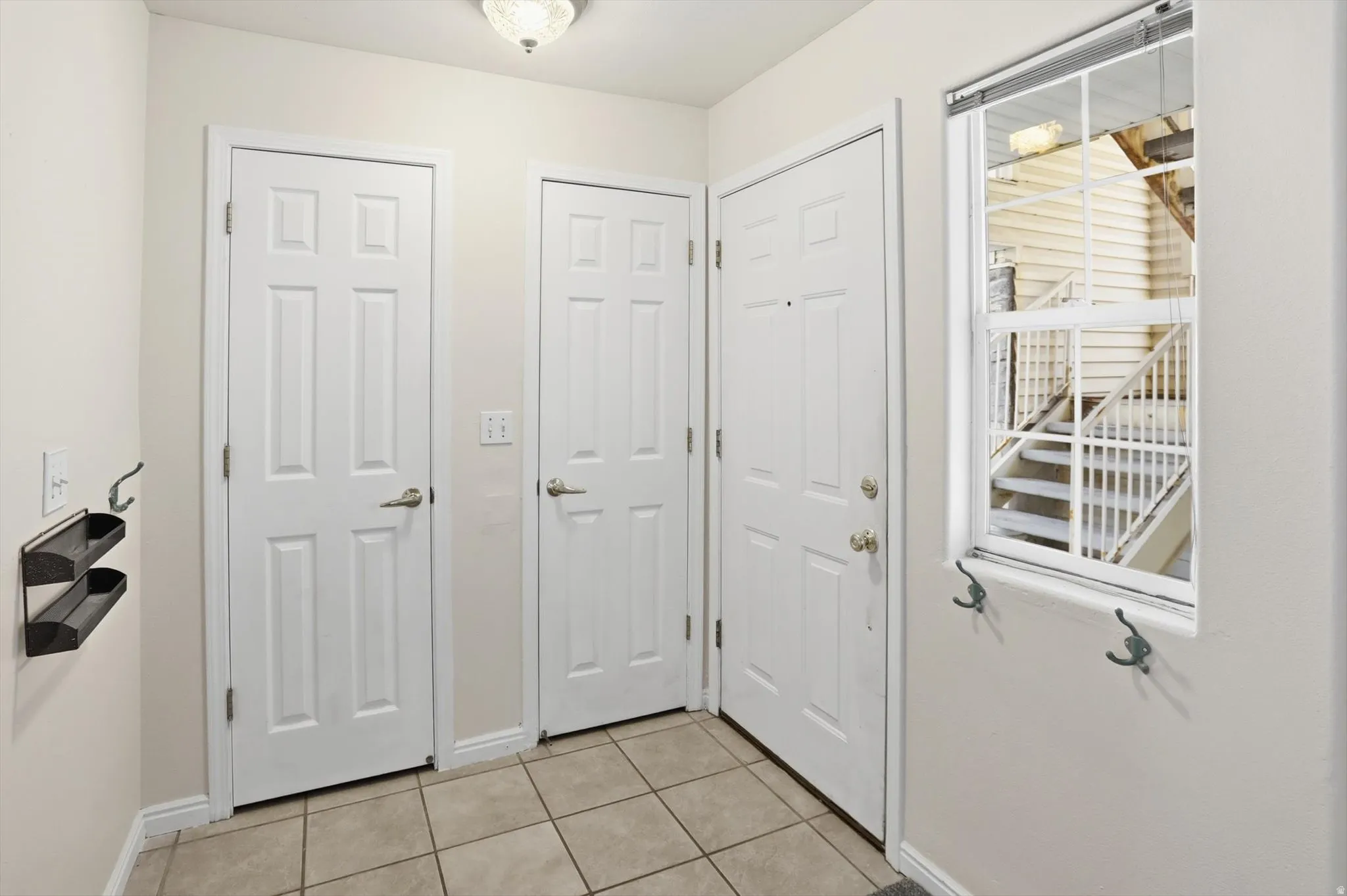 Doorway to outside with tile patterned floors and baseboards