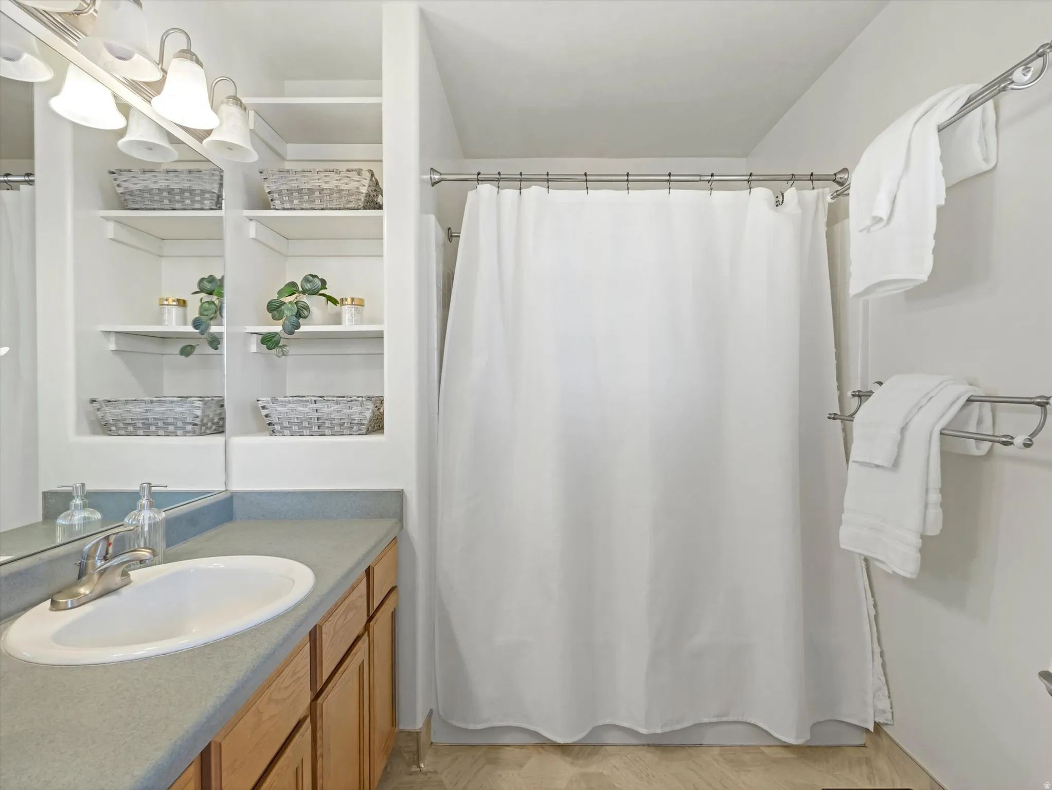 Full primary ensuite bathroom with vanity, shower / tub combo