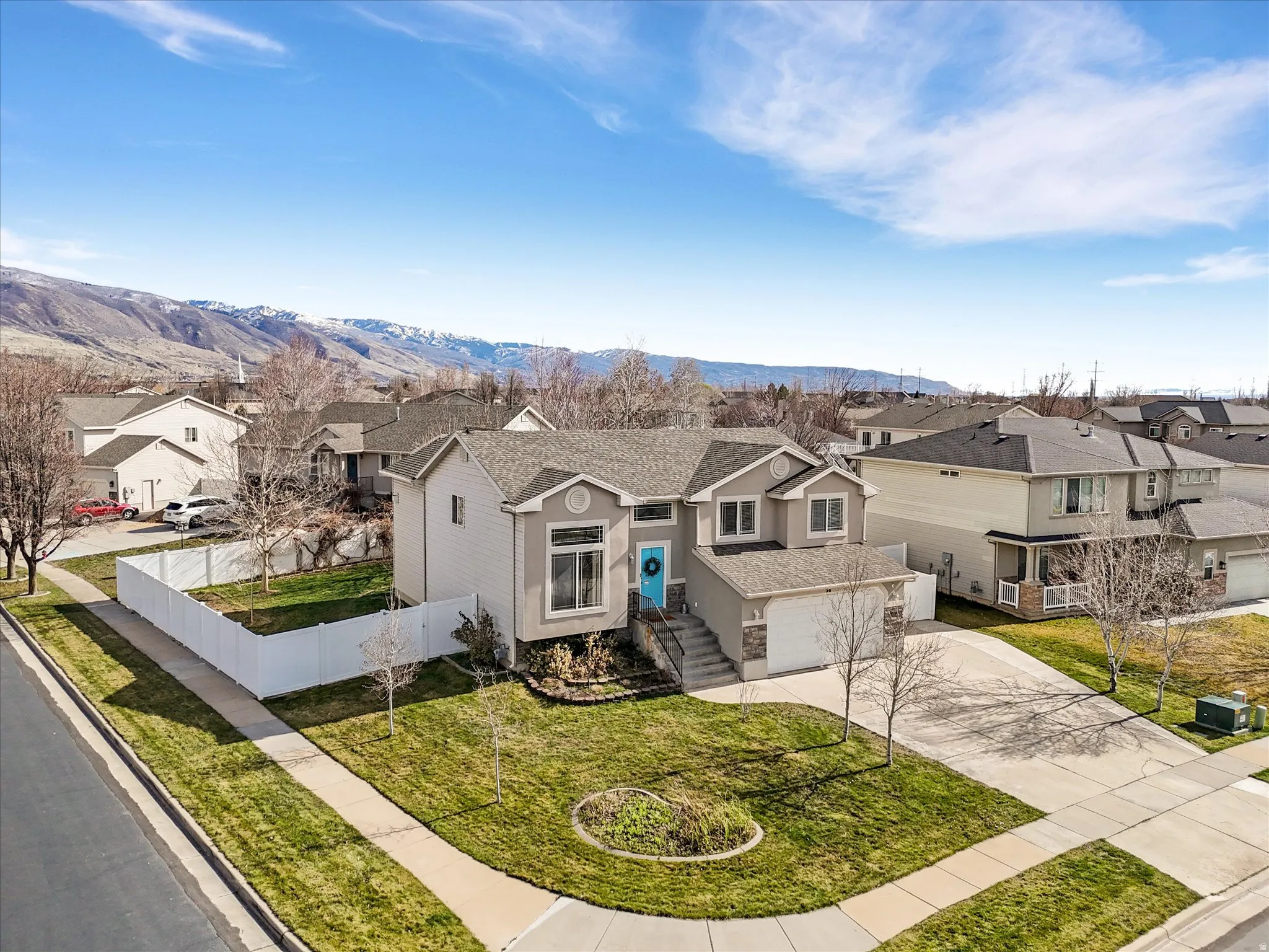 Traditional-style home featuring a residential view, driveway, a shingled roof, a mountain view, and an attached garage