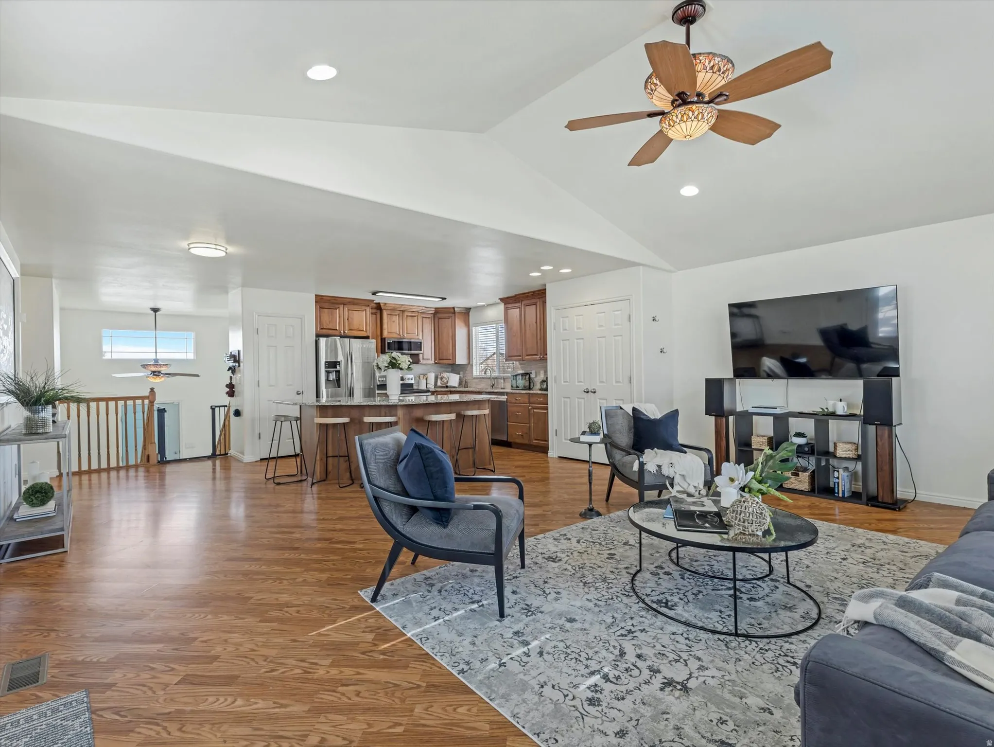 Living area with ceiling fan, light wood finished floors, plenty of natural light, and recessed lighting