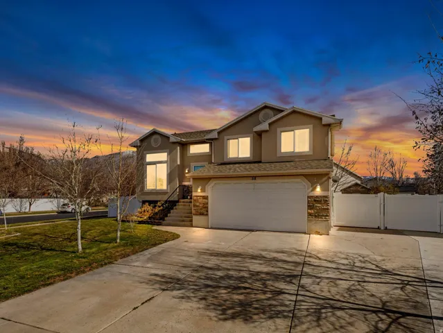 Contemporary two-story residence featuring a two-car garage, stone facade accents, and a concrete driveway