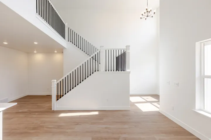 Two-story open-concept interior featuring light wood-finish flooring