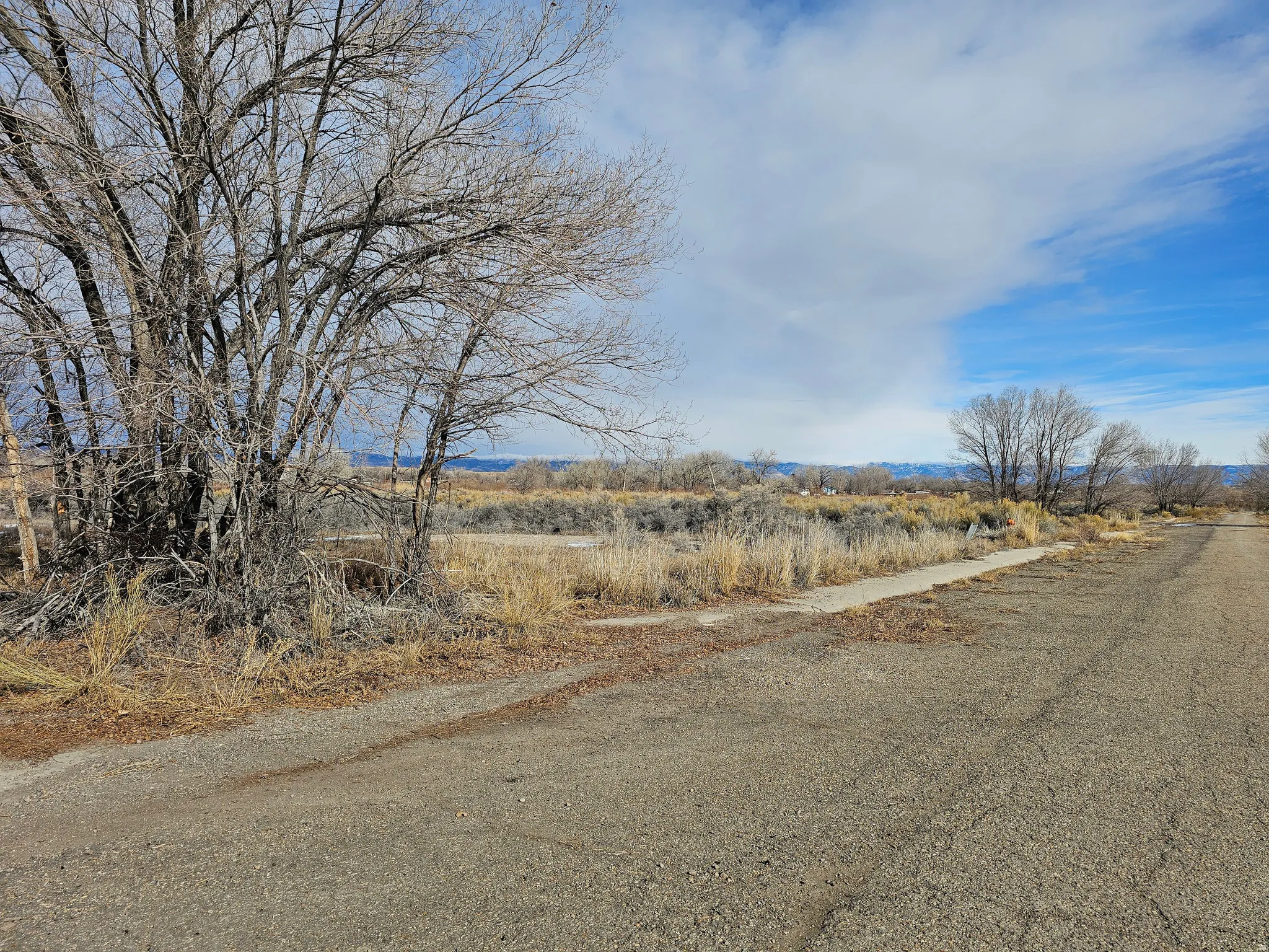 View of asphalt road featuring a view of rural / pastoral area