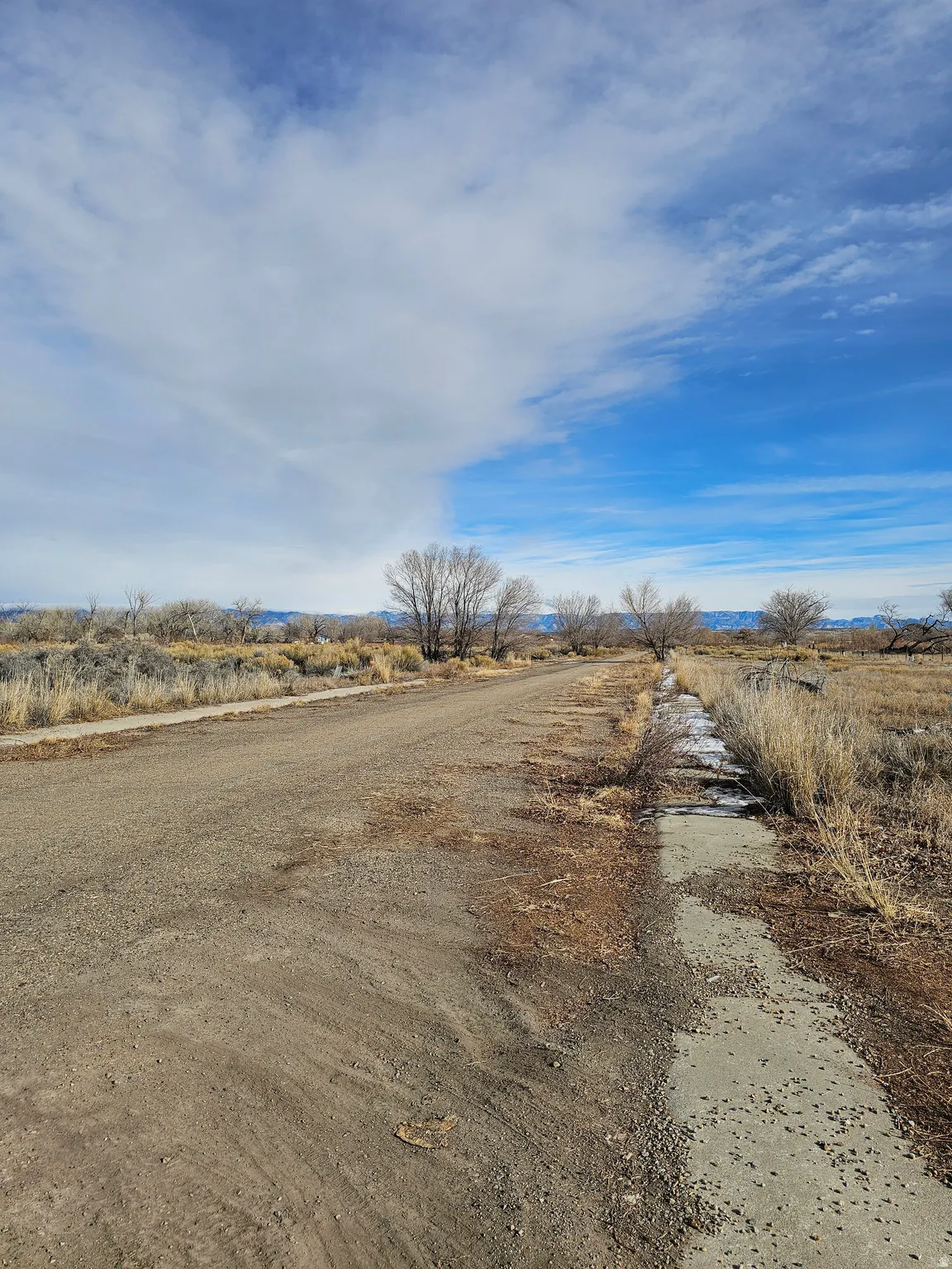 View of dirt / gravel road featuring a view of rural / pastoral area