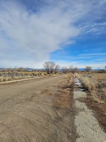 View of dirt / gravel road featuring a view of rural / pastoral area