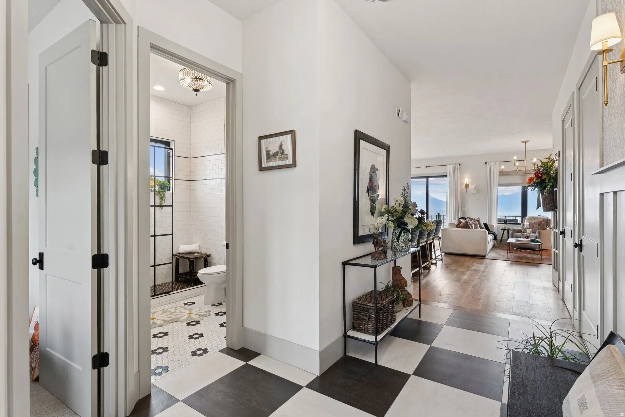 Hallway with healthy amount of natural light, dark floors, and suspended lighting
