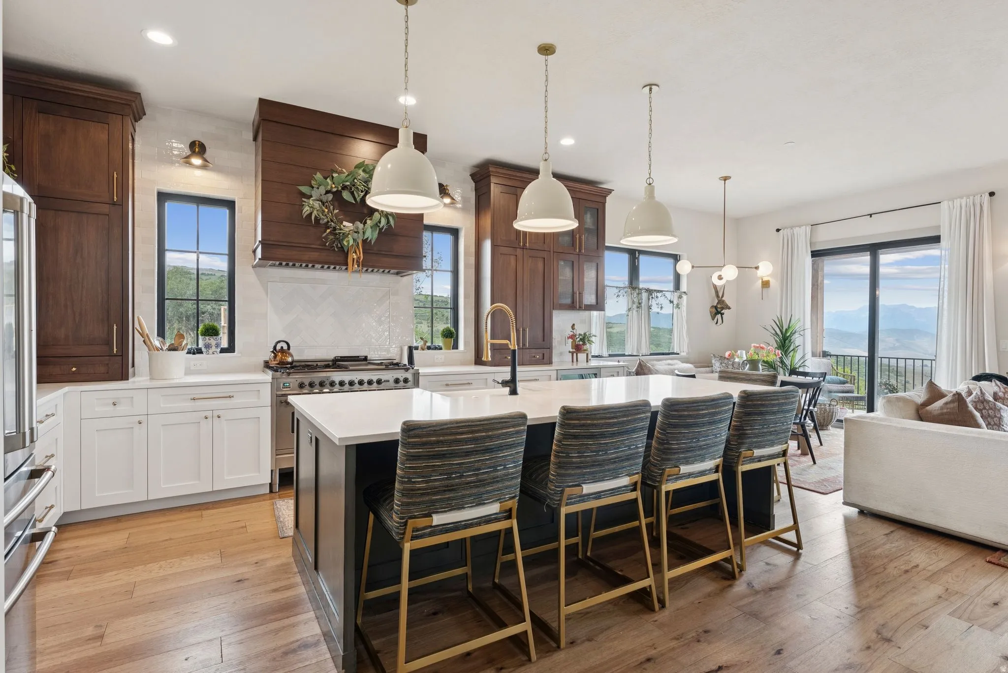 Two tone kitchen with a kitchen breakfast bar, an island with sink, light wood-style floors, tasteful backsplash, and dual tone cabinetry