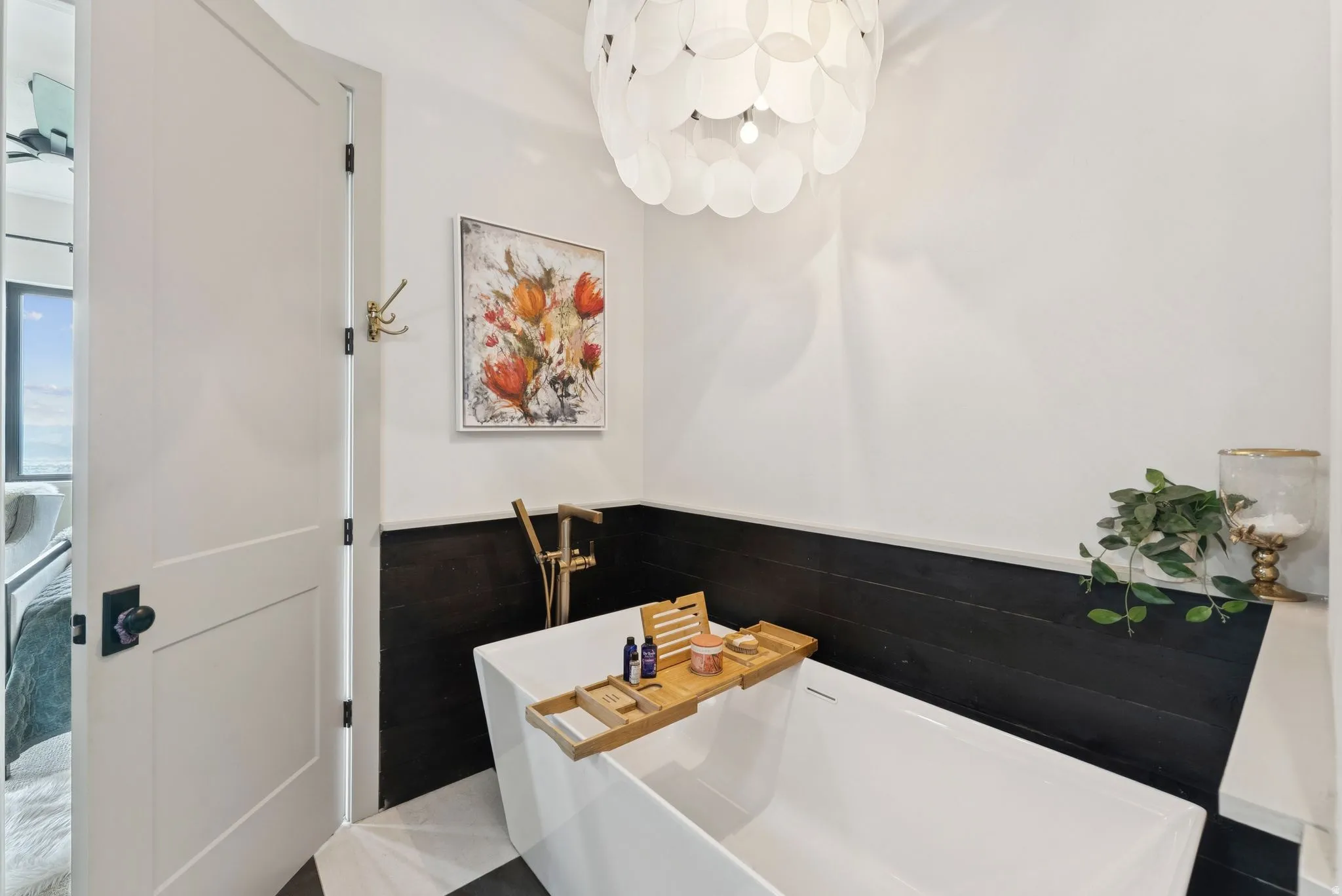 Bathroom featuring a soaking tub and a wainscoted wall