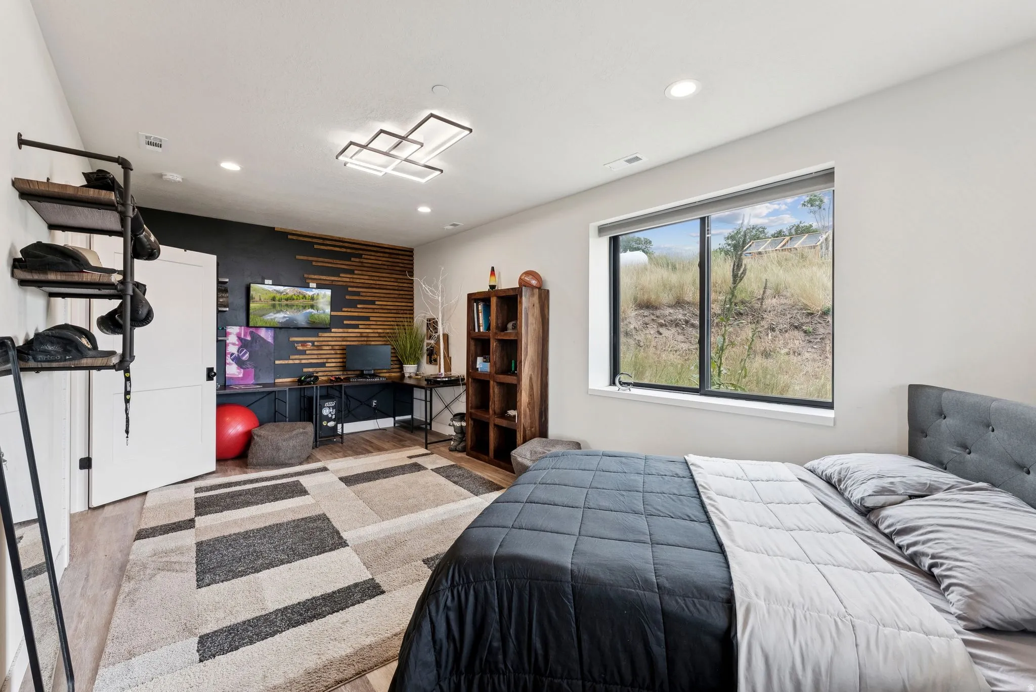 Bedroom with recessed lighting, light wood-type flooring, an office area, and an accent wall