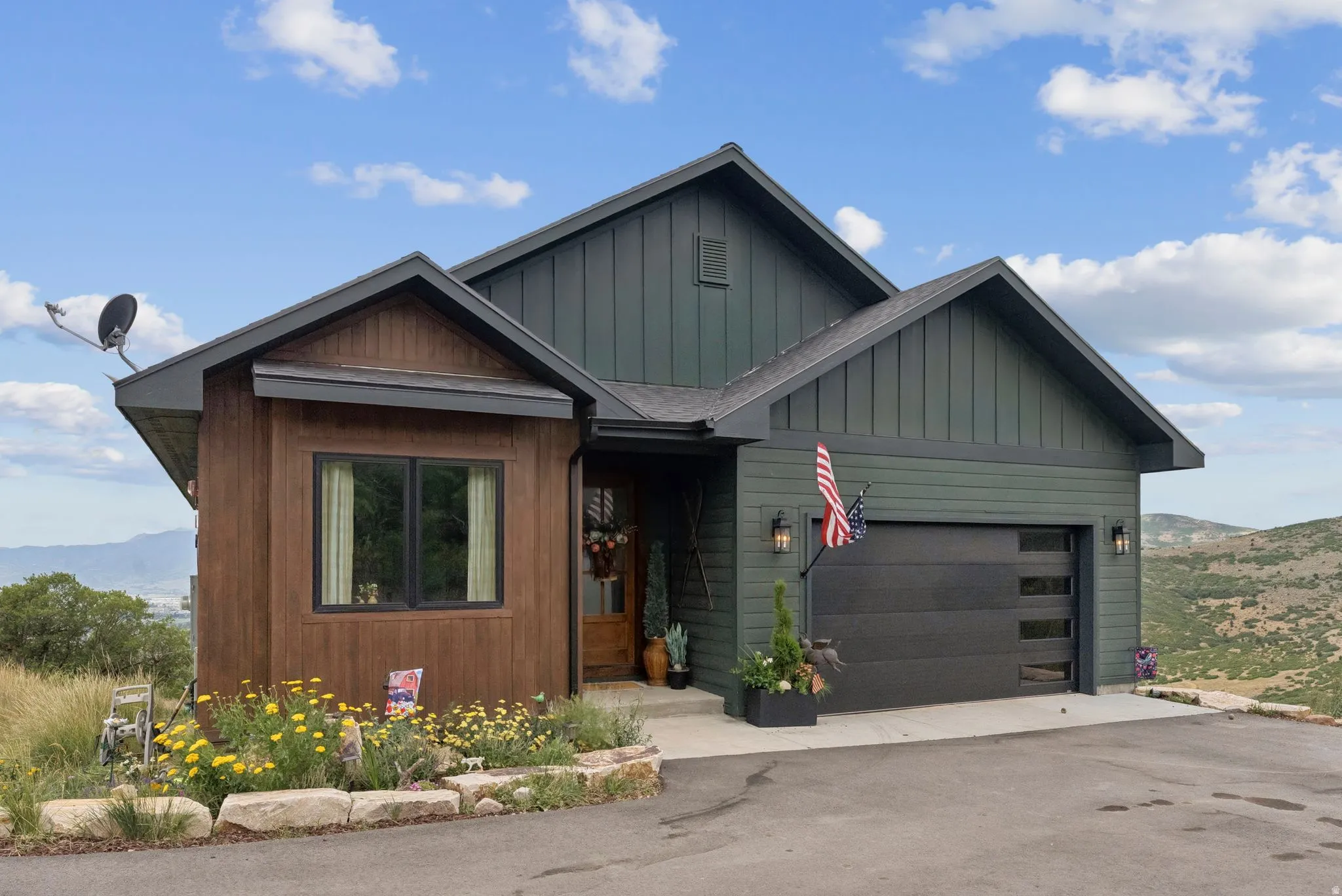 View of front of house featuring a mountain view, board and batten siding, an attached garage, and driveway