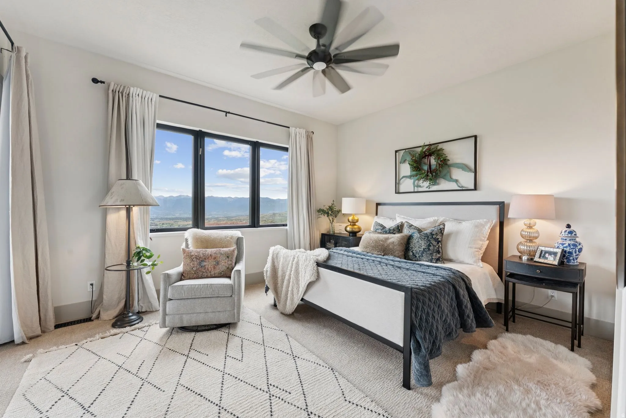 Carpeted bedroom with ceiling fan and a mountain view