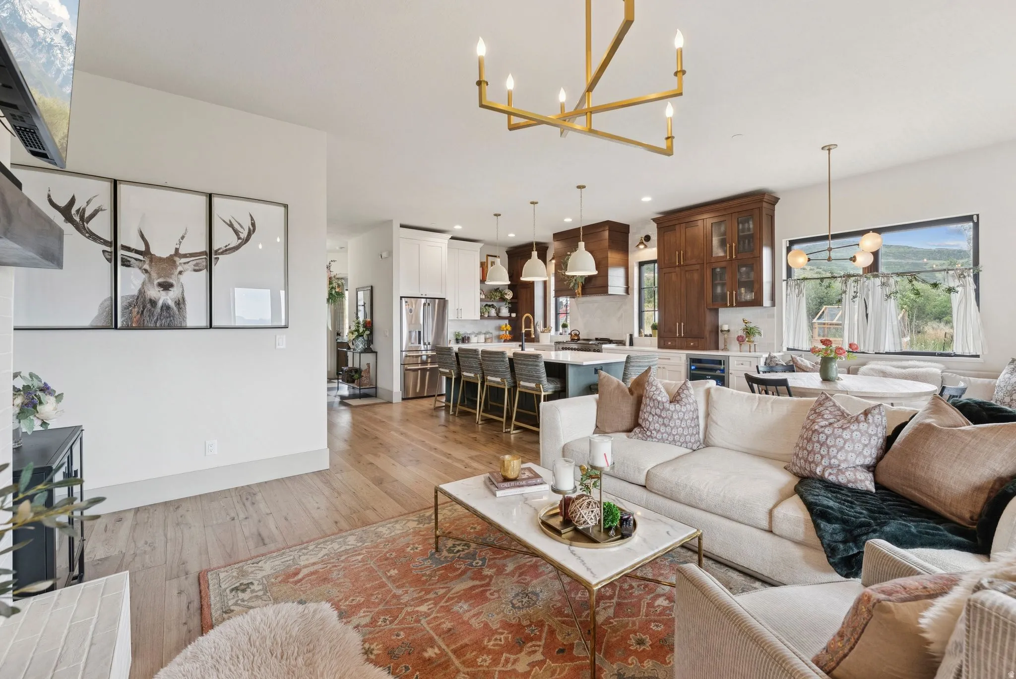 Living room featuring hanging lights, light wood-style flooring, and beverage cooler
