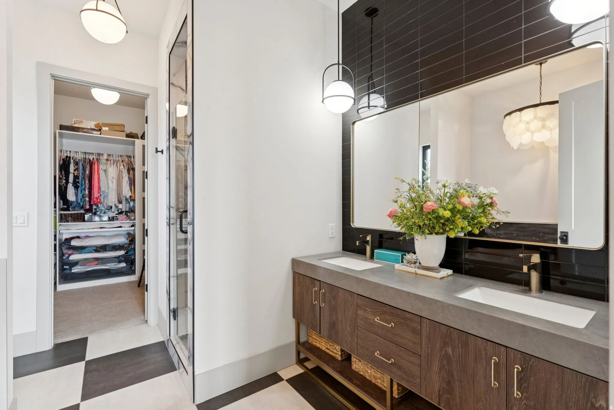 Full bath with light floors, a spacious closet, double vanity, and a stall shower