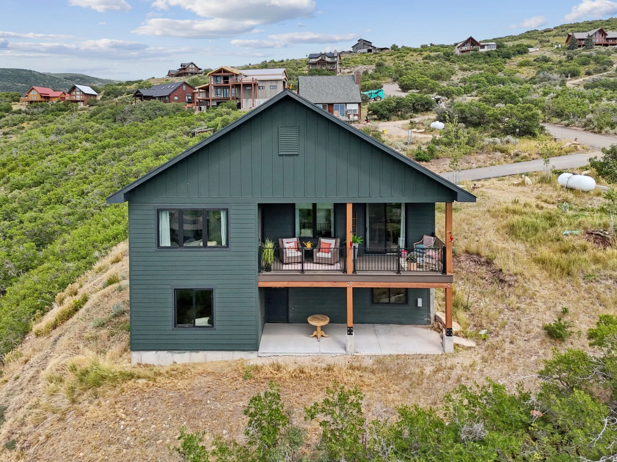 Rear view of property with a patio, board and batten siding, and a wooden deck