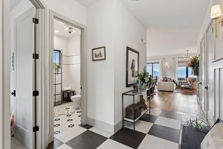Hallway with healthy amount of natural light, dark floors, and suspended lighting