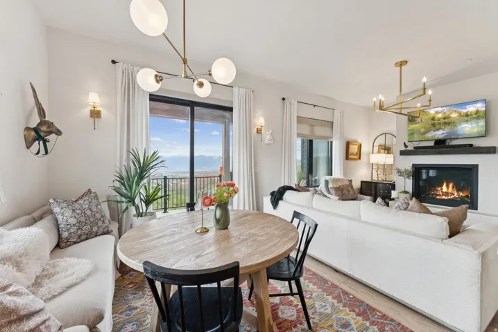 Dining space featuring suspended lighting, a glass covered fireplace, and wood finished floors
