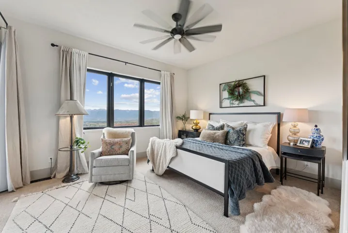 Carpeted bedroom with ceiling fan and a mountain view