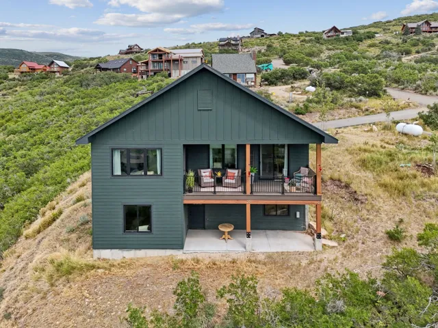 Rear view of property with a patio, board and batten siding, and a wooden deck