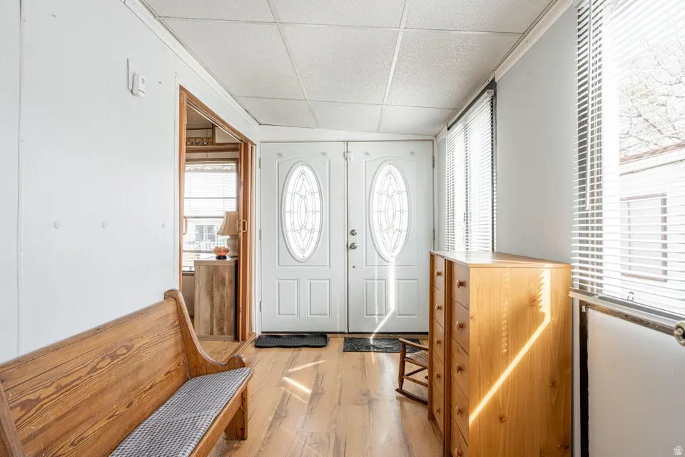 Entrance foyer with light wood-style flooring and a drop ceiling