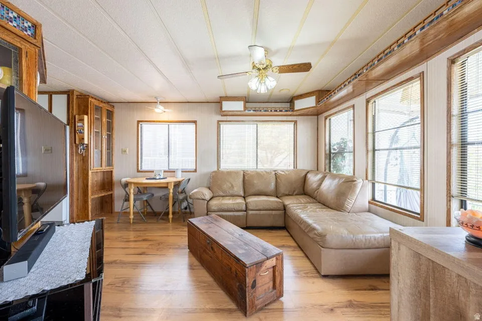 Living area with light wood-style floors and ceiling fan