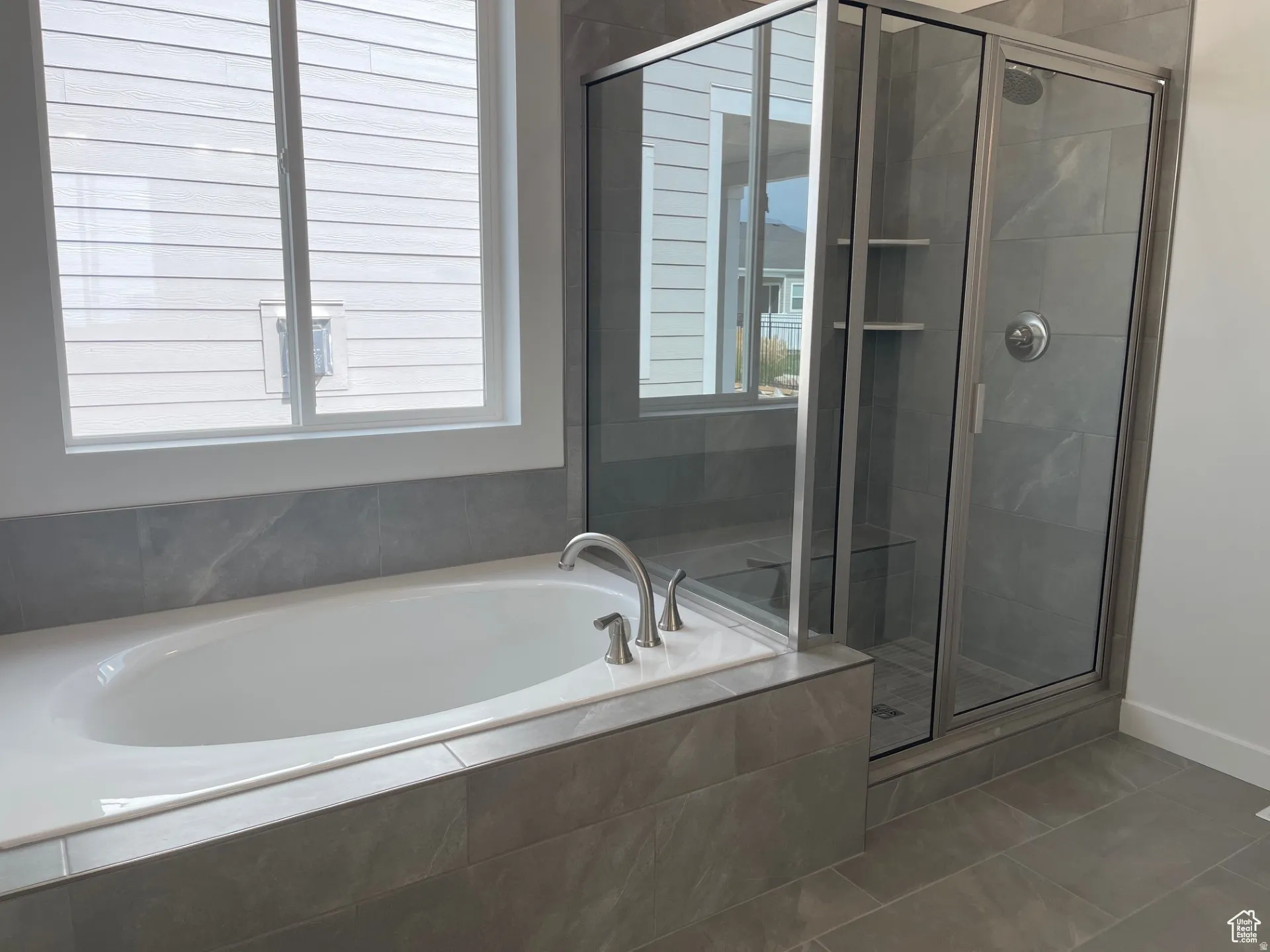 Full bath featuring a stall shower, a garden tub, and tile patterned flooring