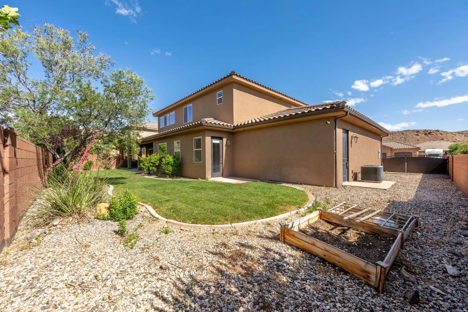 Rear exterior featuring stucco finish, tile roof, and multiple windows