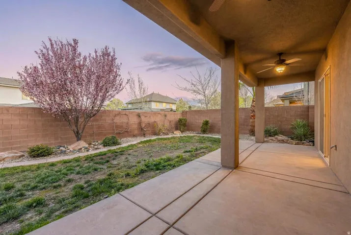 Fenced backyard featuring a ceiling fan and a patio area
