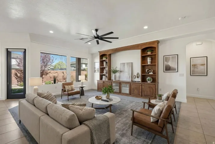 Living room with light tile patterned floors, a ceiling fan, built in features, and recessed lighting