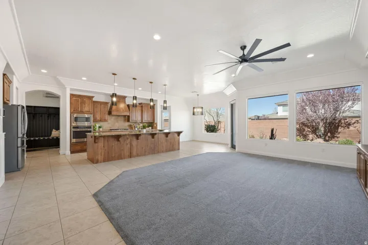Living room with light tile patterned floors, a ceiling fan, and recessed lighting