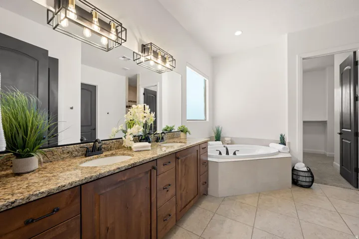 Full bathroom featuring double vanity, a bath, light tile patterned floors, a closet, and recessed lighting
