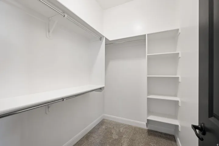 Walk in closet featuring dark colored carpet