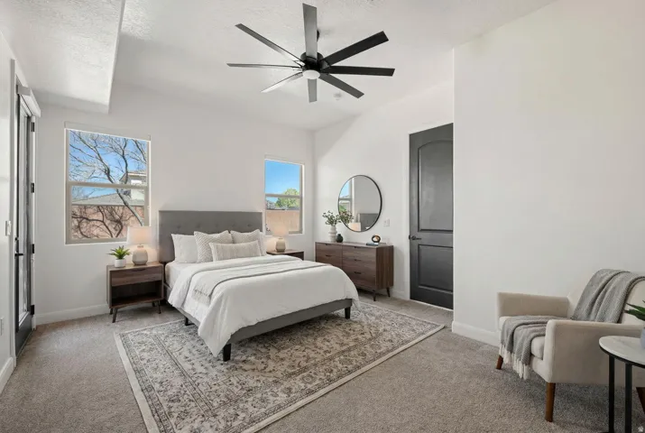 Carpeted bedroom with a ceiling fan and a textured ceiling