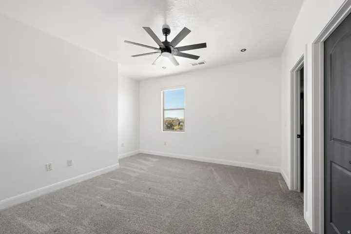 Unfurnished bedroom featuring a ceiling fan, carpet floors, and a textured ceiling