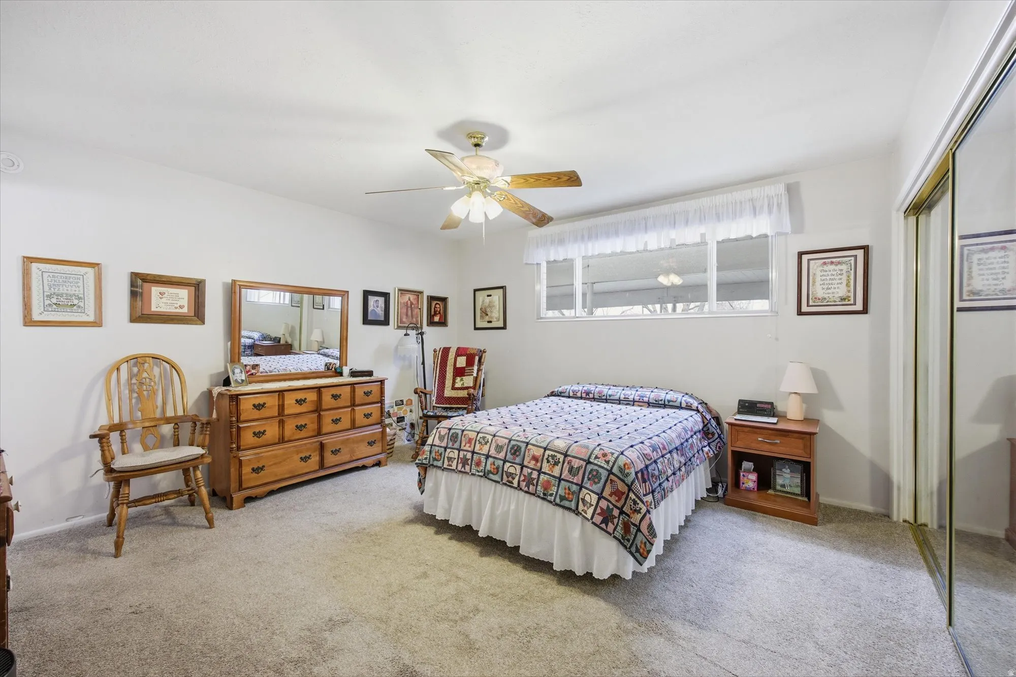 Bedroom featuring a closet, a ceiling fan, and light carpet