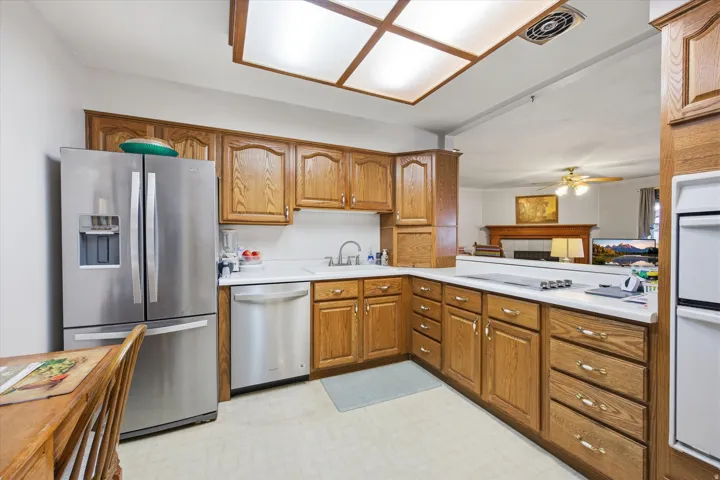Kitchen with light countertops, stainless steel appliances, wood finish cabinets, and light flooring
