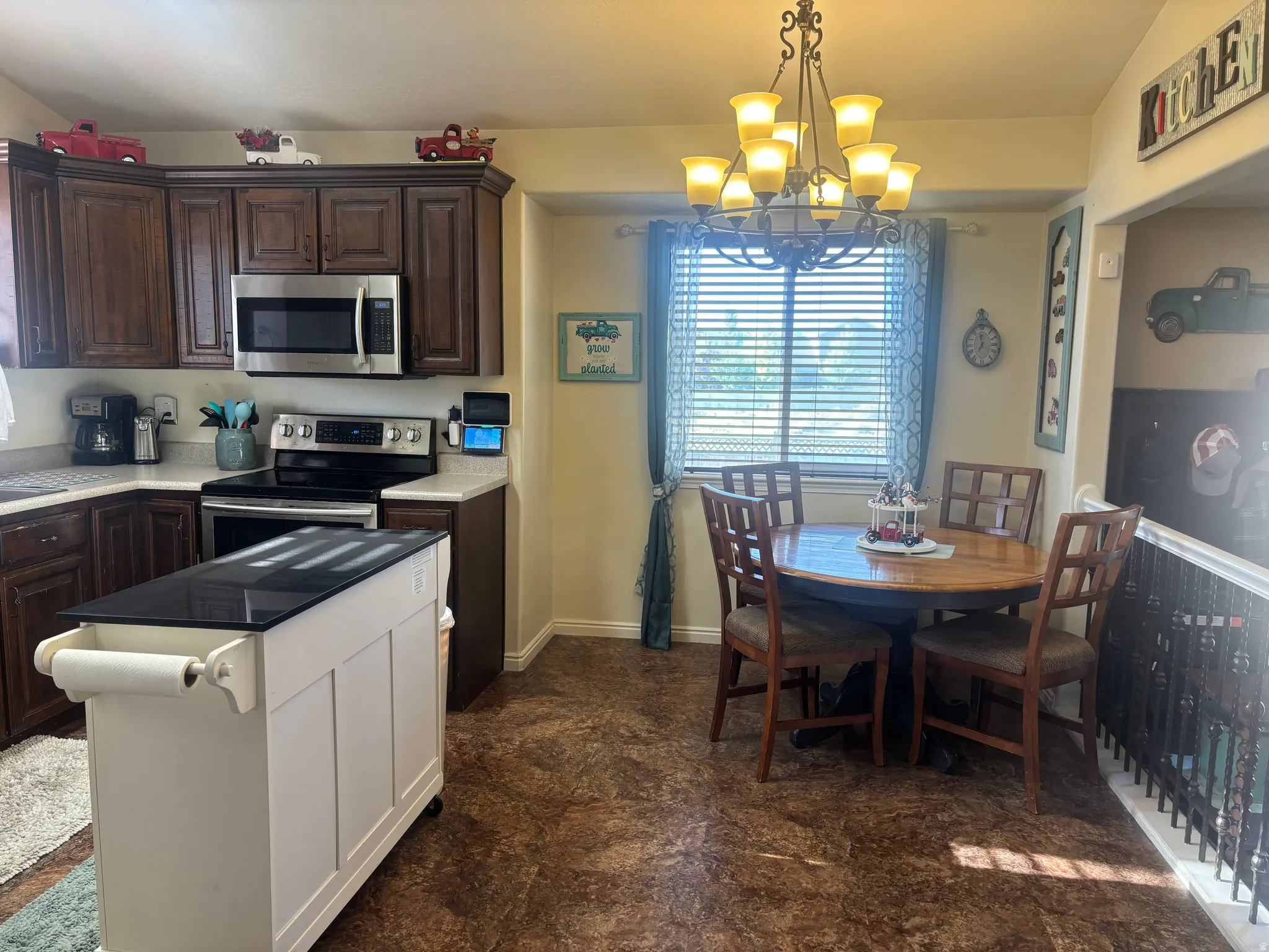 Kitchen with dark wood finish cabinets, stainless steel appliances, and a chandelier
