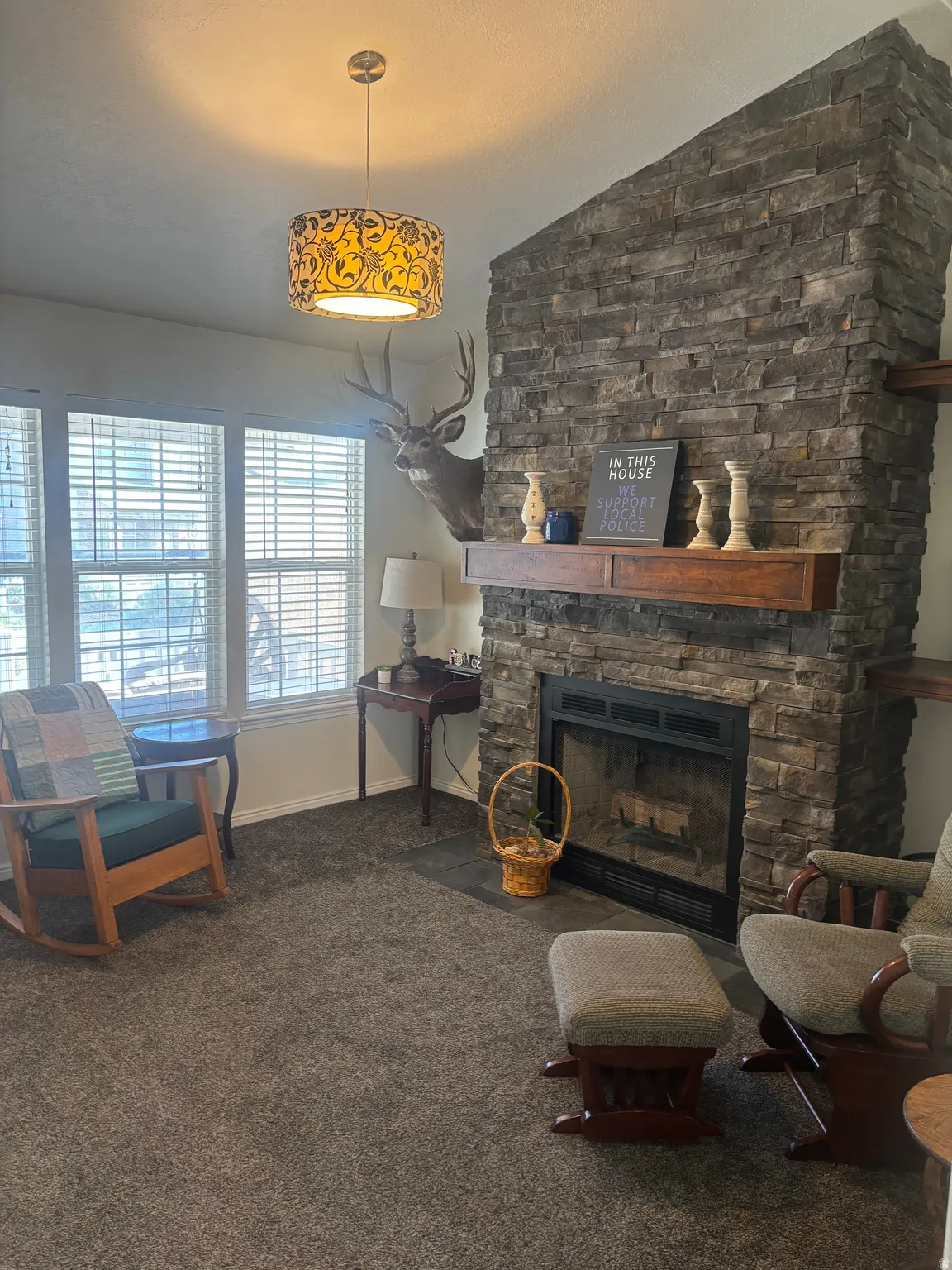 Living area with a fireplace, lofted ceiling, and dark colored carpet