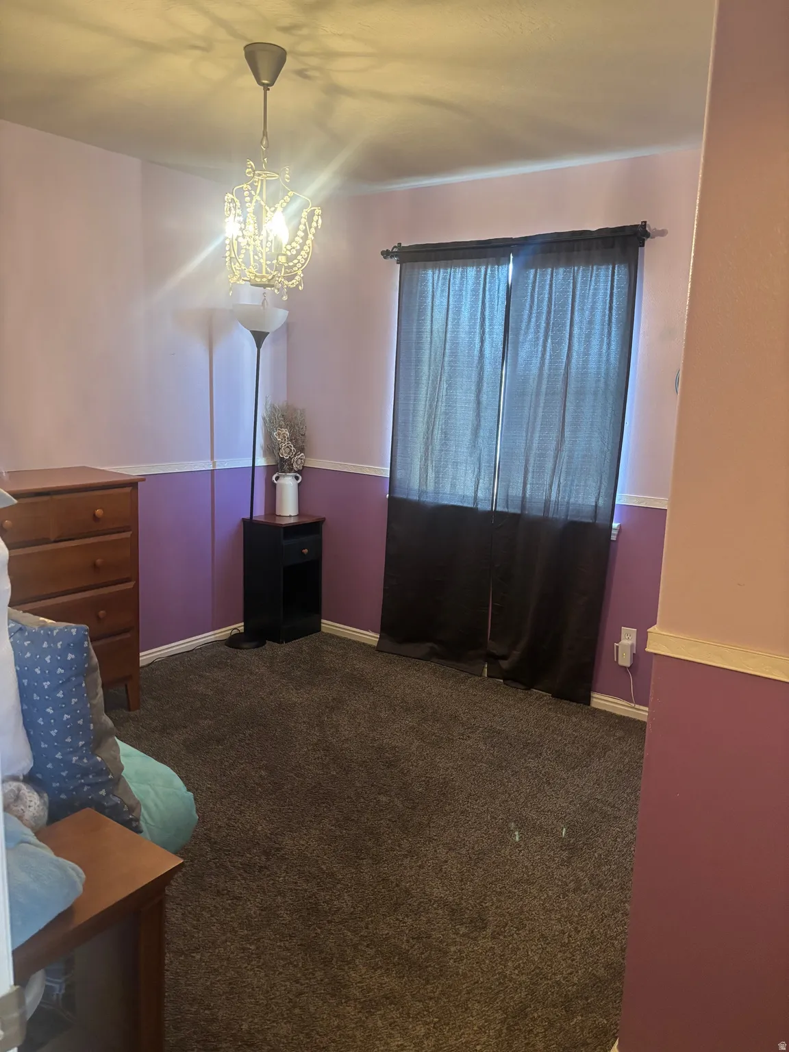Bedroom with dark carpet and hanging lights