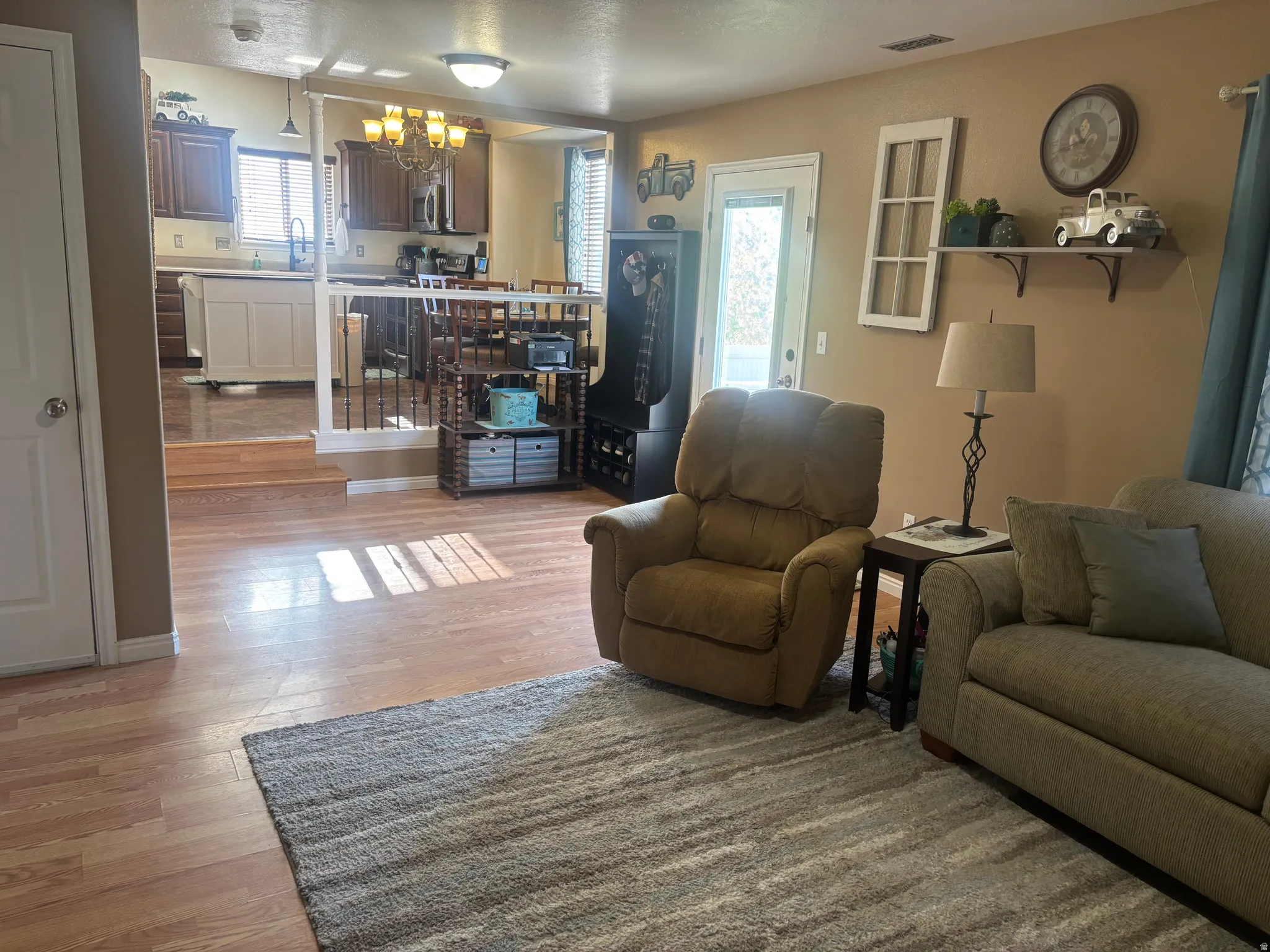 Living area with a chandelier and light wood-type flooring