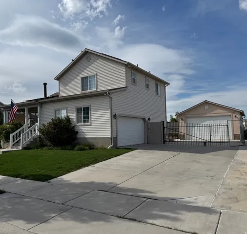 Two-story residence featuring light-colored siding and a two-car attached garage