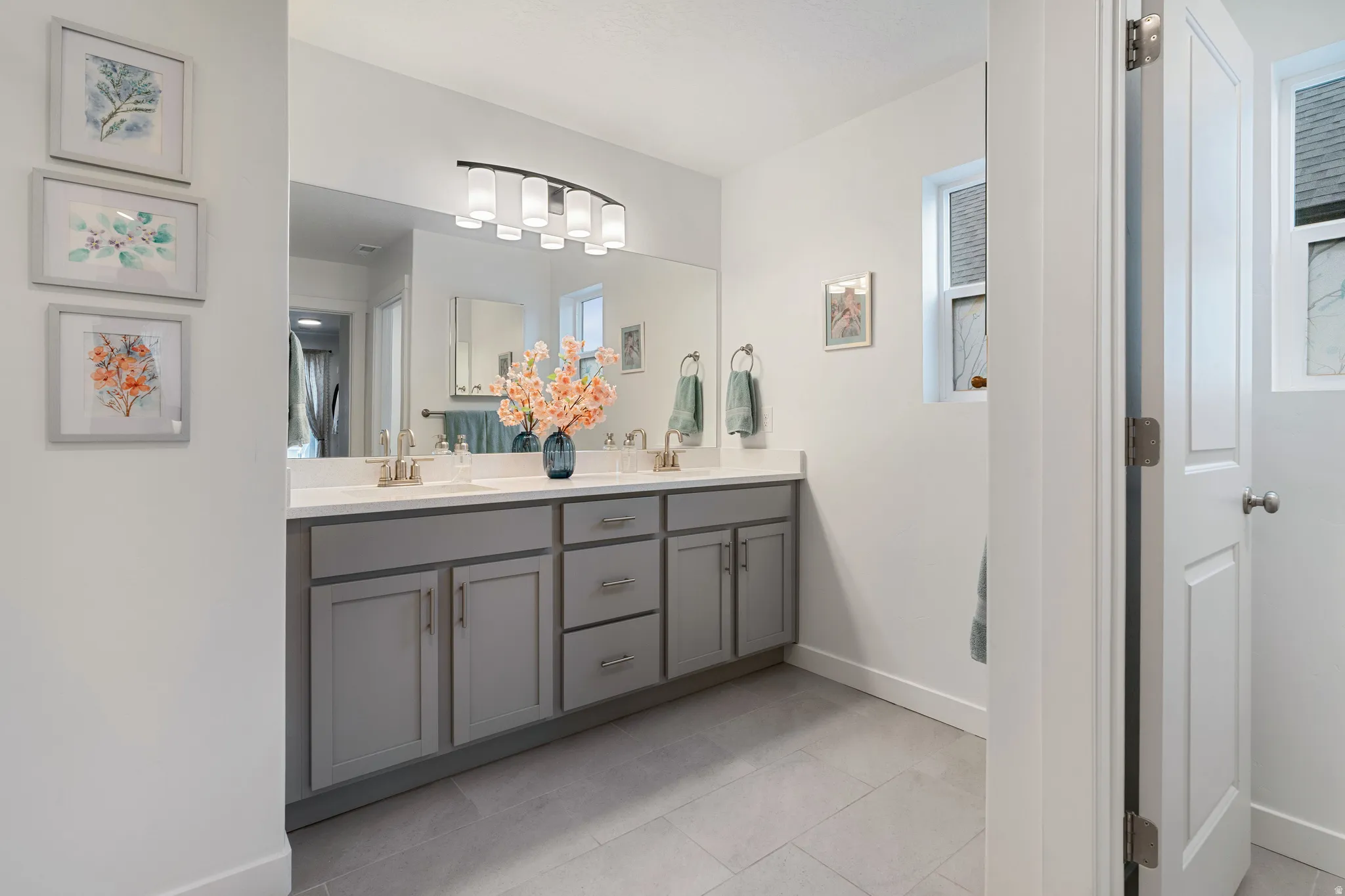 Primary Full bath with double vanity and light tile patterned floors