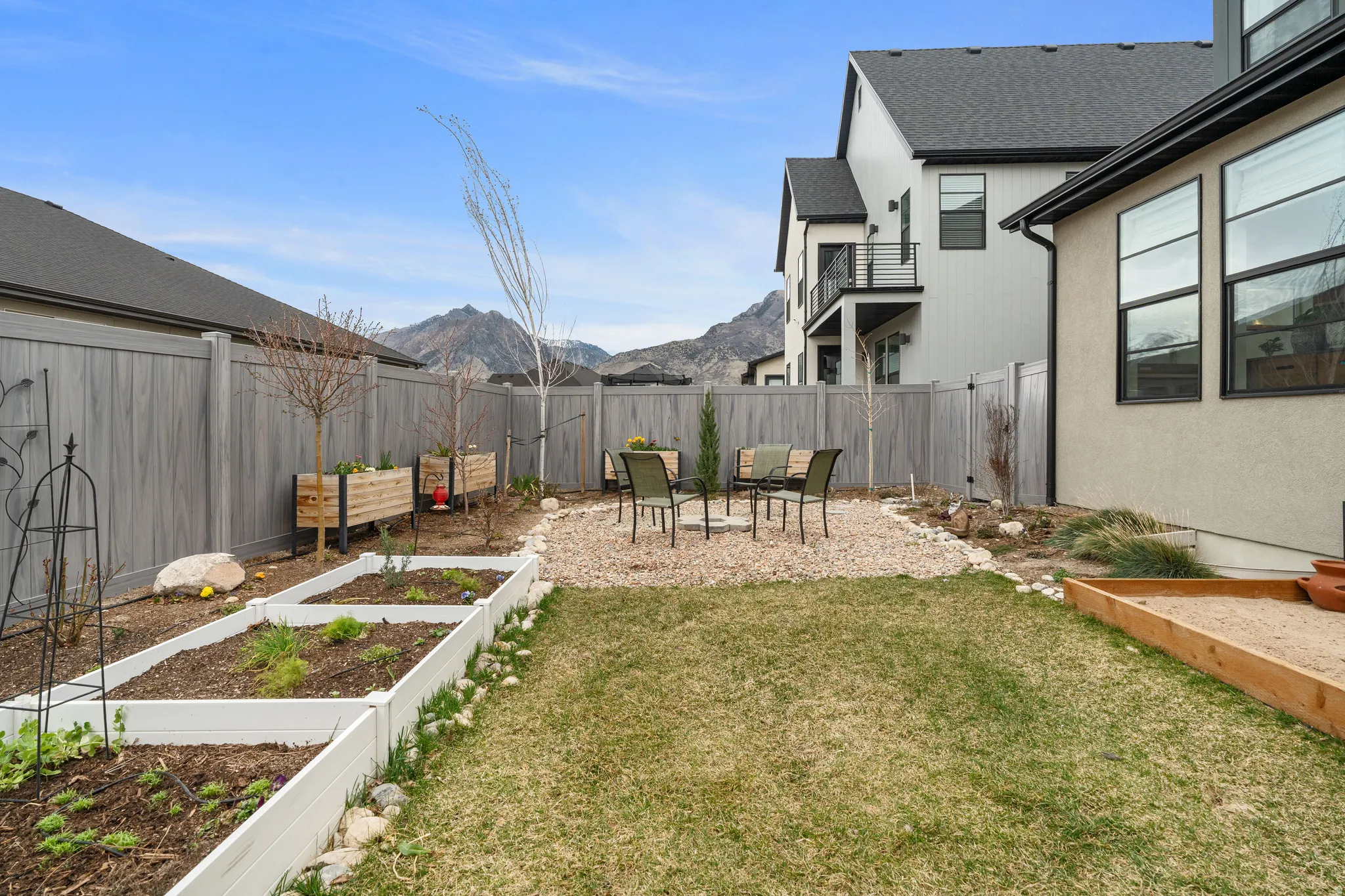 Fenced backyard featuring a patio area, a mountain view, a garden, and a balcony
