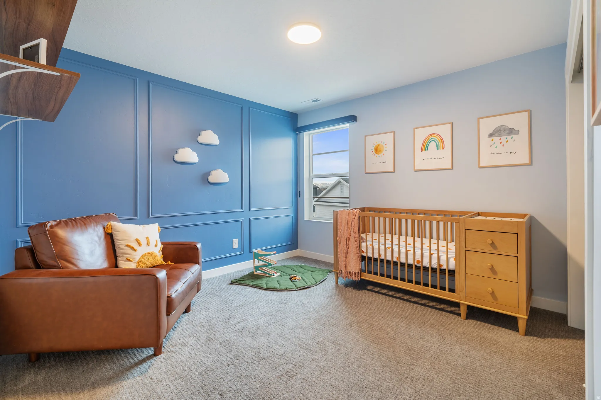 Bedroom featuring a decorative wall, a nursery area, and carpet floors