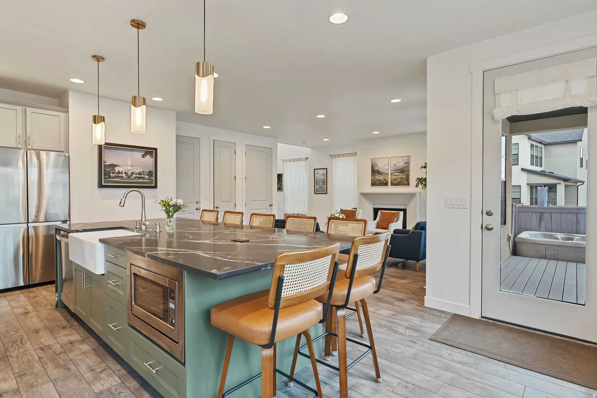 Kitchen with a breakfast bar, stainless steel appliances, a center island with sink, and light wood finished floors