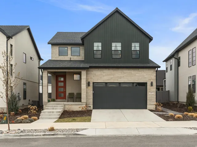 Modern farmhouse featuring a garage and concrete driveway