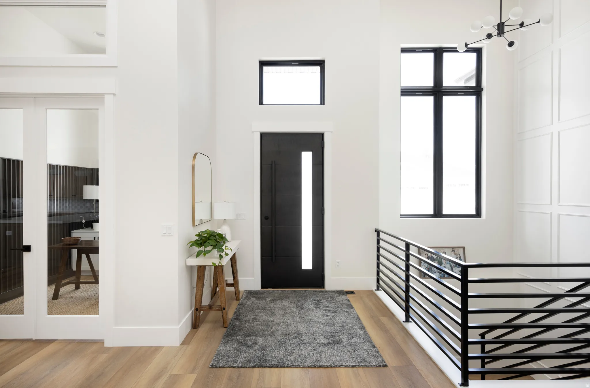 Foyer entrance with light wood-style flooring, a high ceiling, and plenty of natural light