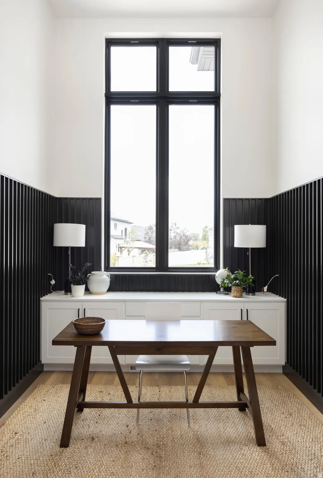 Office space with a wainscoted wall and light wood-style flooring
