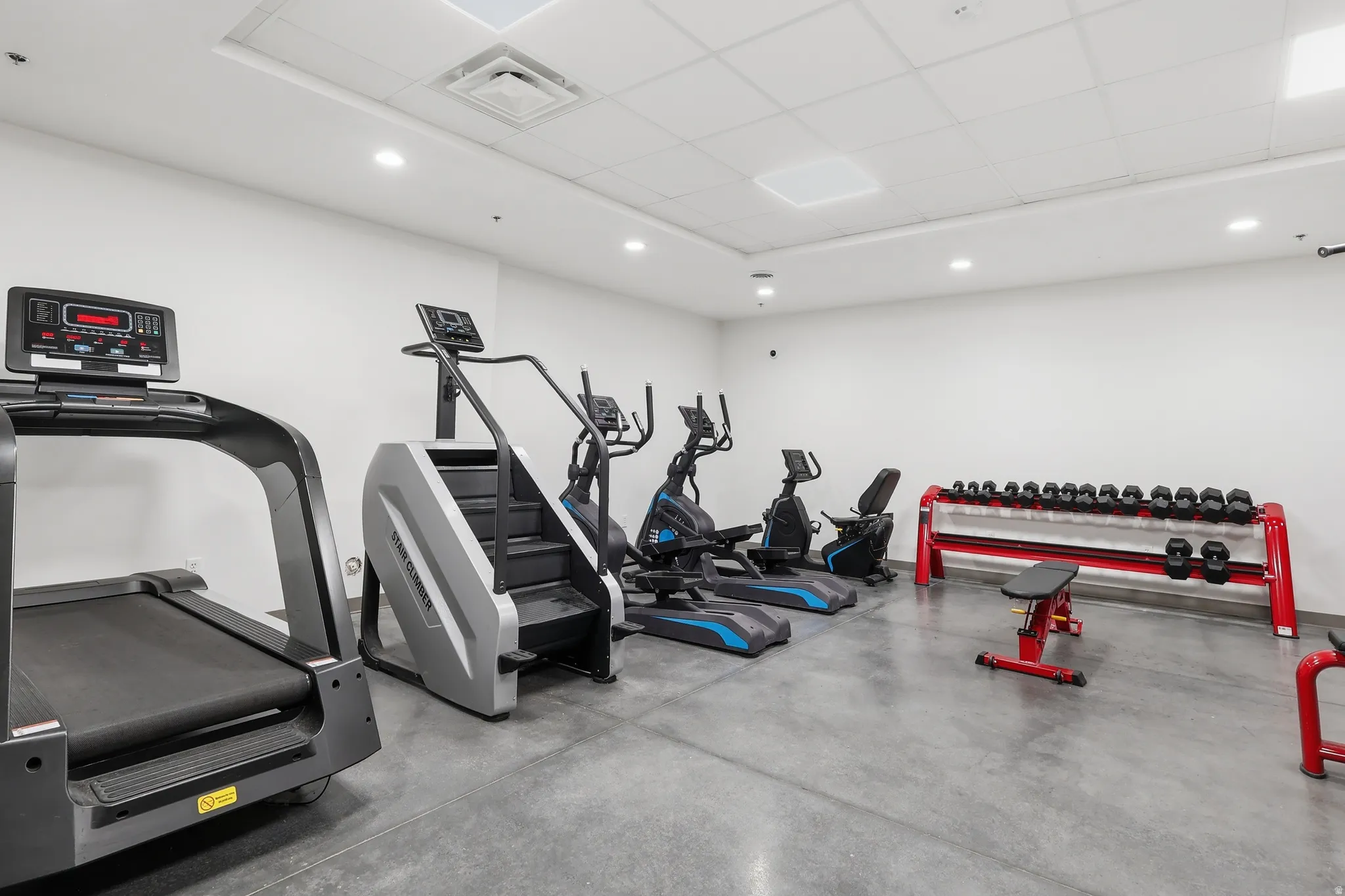 Gym with a paneled ceiling and recessed lighting