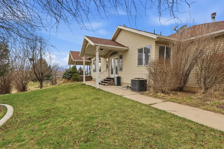 View of side of home featuring a lawn and a shingled roof
